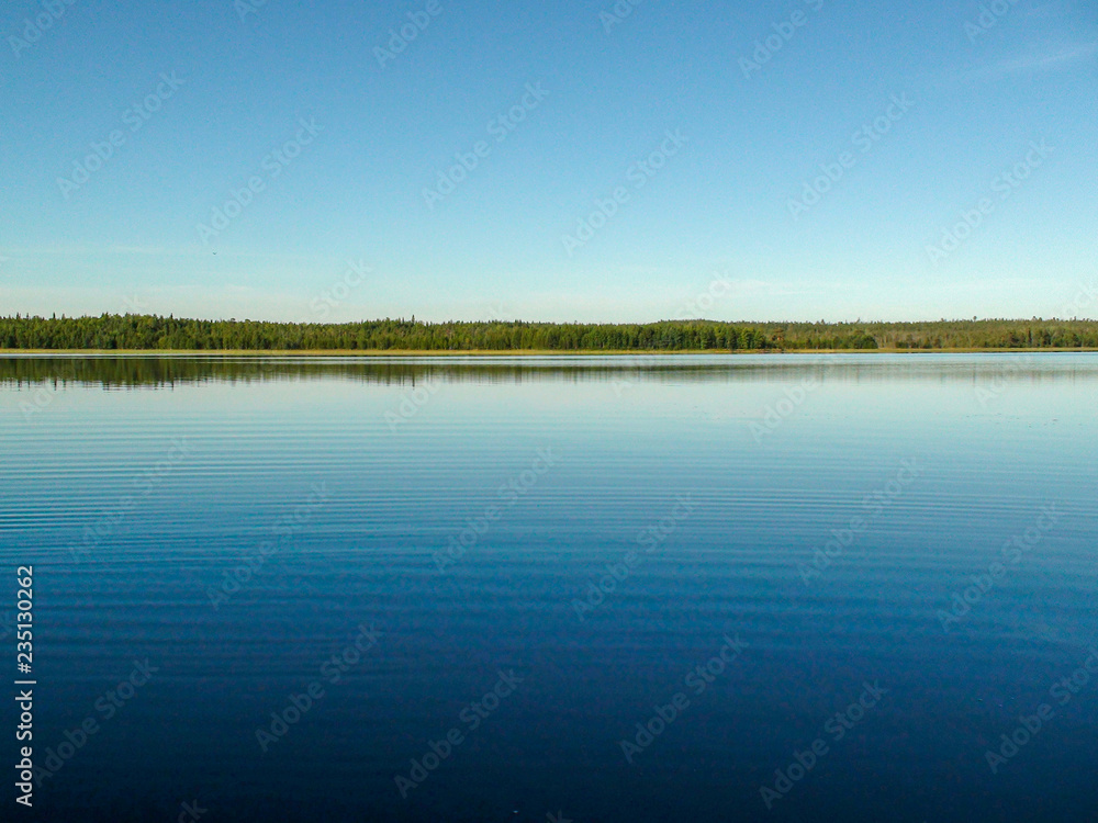 The surface of the blue lake and the blue sky is divided by the coastline The surface of the blue lake and the blue sky is divided by the coastline