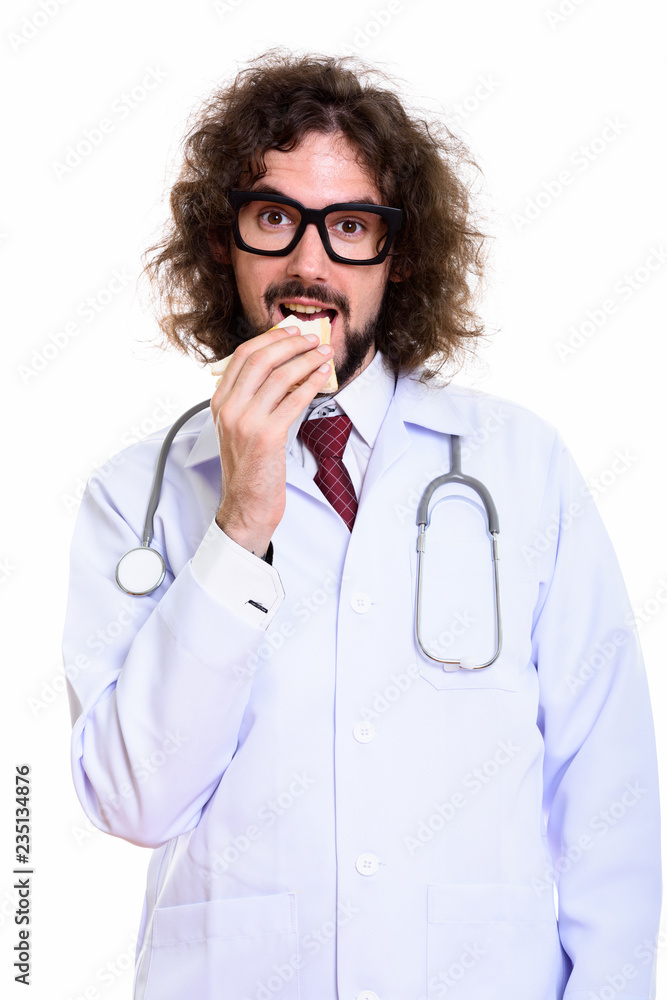 Studio shot of happy man doctor smiling and eating sandwich Studio shot of happy man doctor smiling and eating sandwich