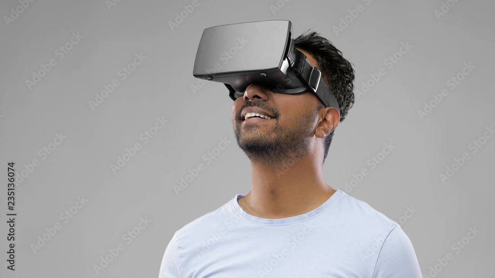 3d technology, virtual reality, entertainment and people concept - young man in vr glasses playing game over grey background 3d technology, virtual reality, entertainment and people concept - young man in vr glasses playing game over grey background