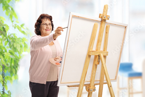 Elderly woman painting on a canvas