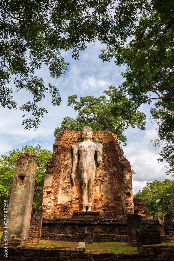 Obraz premium Big antique standing or walking buddha in world heritage Kamphaeng Phet historical park, Thailand. Wat Phra Si Ariyabot temple.