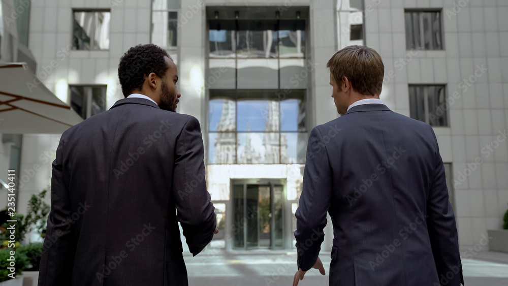 Business partners approaching office center, discussing mutual work, cooperation Business partners approaching office center, discussing mutual work, cooperation