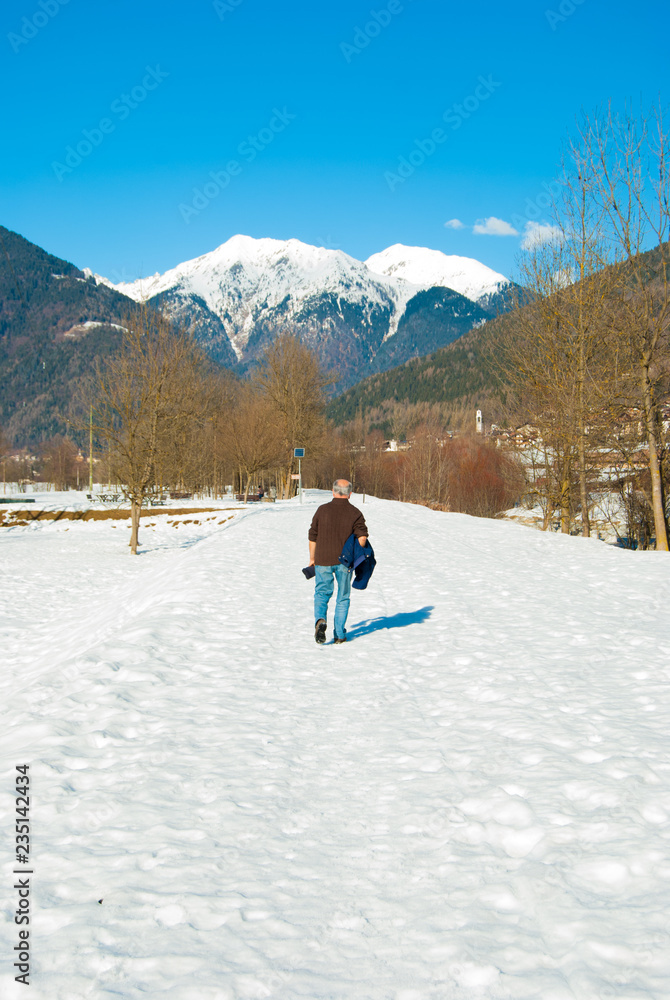 One elderly walking on a snowy road