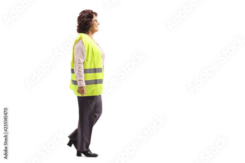 Elderly woman wearing a safety vest walking