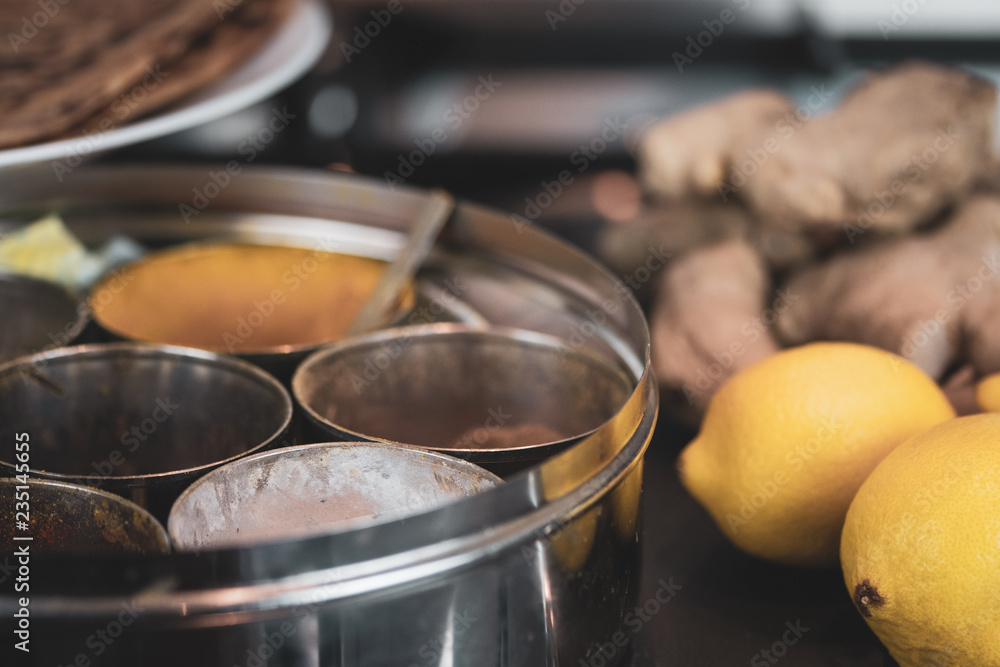 A round container for spices - with ginger and roti - cooking Indian food. A round container for spices - with ginger and roti - cooking Indian food.