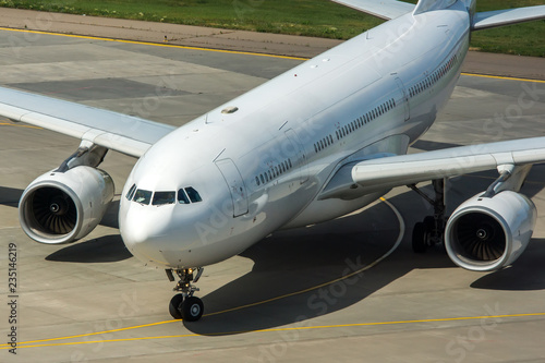 Modern passenger civil airplane taxiing at international airport