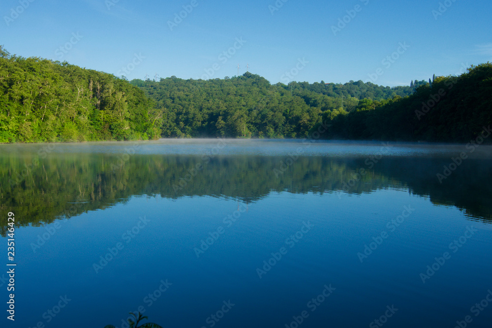 Nature landscape of the Arno River with woods and reflection on the water