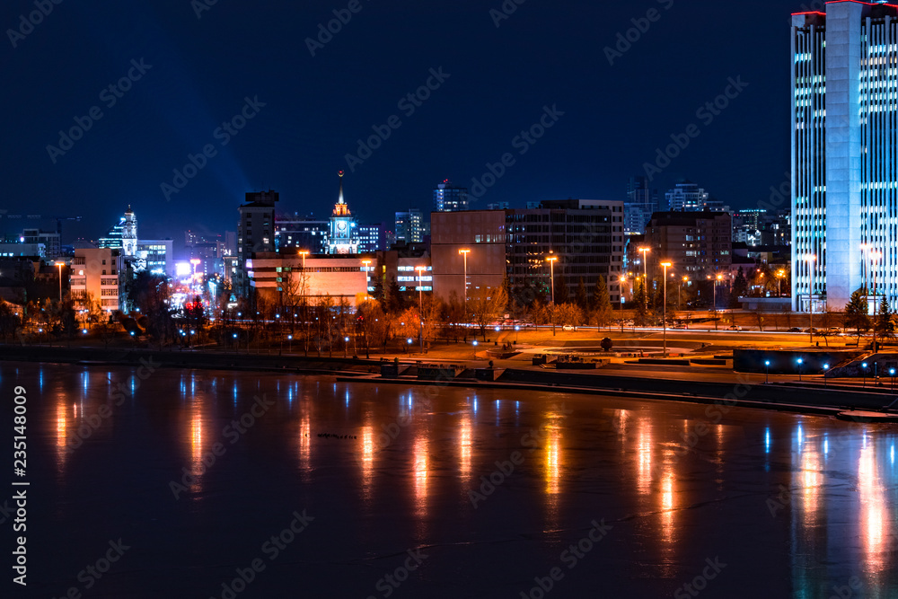 Beautiful night cityscape view of Yekaterinburg center and city pond. City lights reflections on water