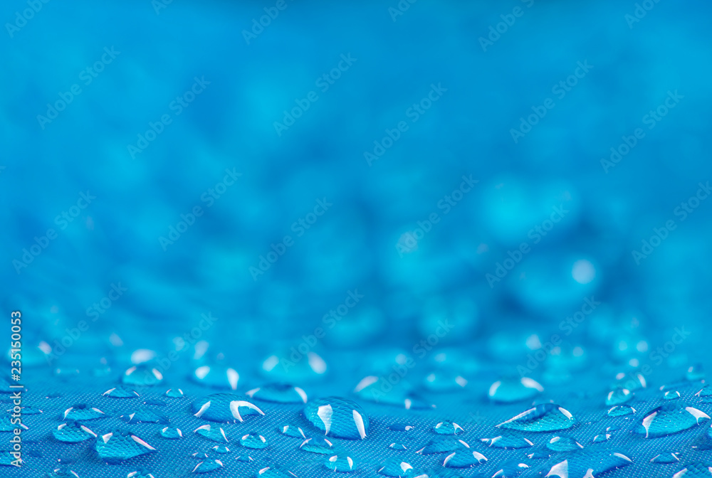 Water drops on waterproof nylon fabric. Nylon waterproof fabric with heavy blurred background and focused on the foreground water drops - obrazy, fototapety, plakaty 