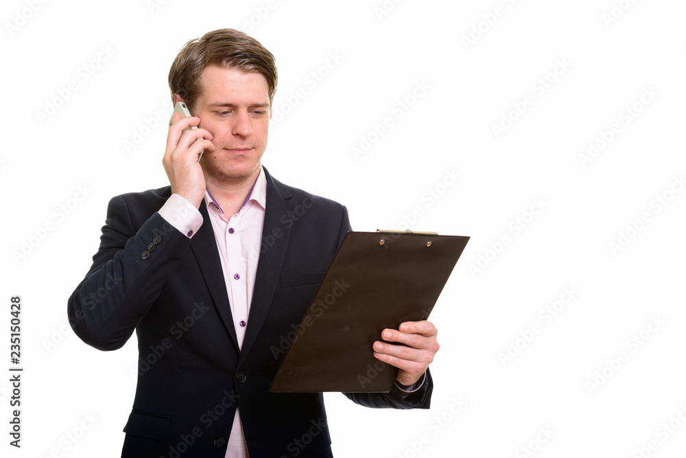 Handsome Caucasian businessman reading clipboard while talking o Handsome Caucasian businessman reading clipboard while talking o