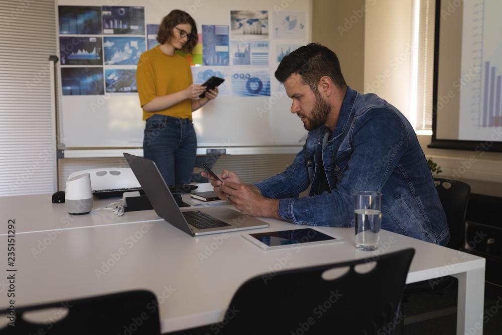 Executive using mobile phone in office Executive using mobile phone in office