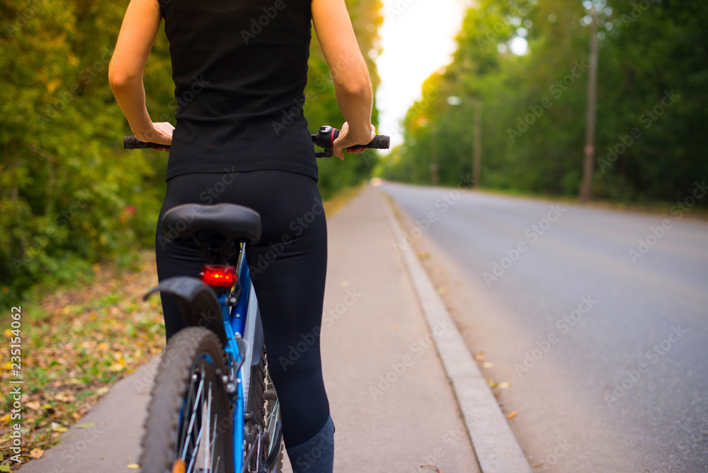 Close-up of women's sports ass in leggings. blue bike on the background of  the road going into the distance Stock Photo | Adobe Stock