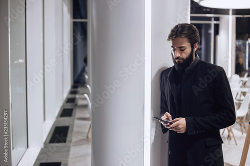 Modern man looking at his smartphone © Ivan