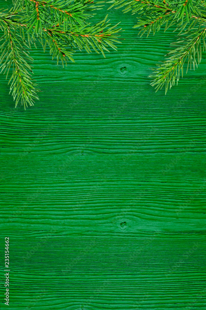 green spruce branches on a green wooden board. Christmas background green spruce branches on a green wooden board. Christmas background