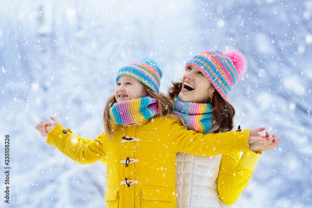 Mother and child in knitted winter hats in snow. Mother and child in knitted winter hats in snow.
