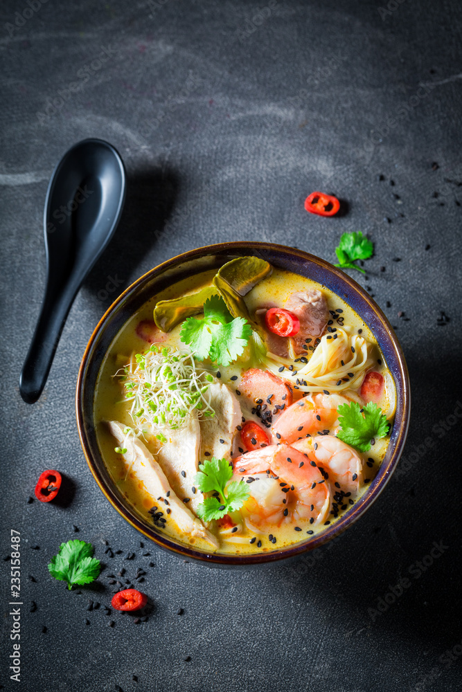 Malaysian Soup with chicken and shrimps on concrete table Malaysian Soup with chicken and shrimps on concrete table