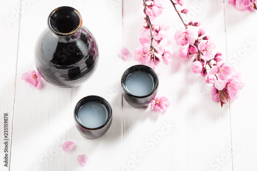 Top view of sake with flowers of blooming cherry