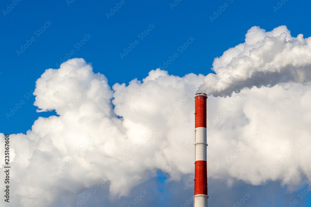Upper part of the smoking pipe of a power plant against a blue sky. Upper part of the smoking pipe of a power plant against a blue sky.