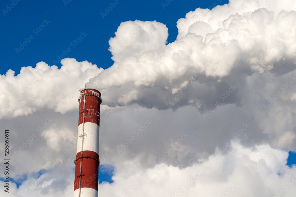 Upper part of the smoking pipe of a power plant against a blue sky. Upper part of the smoking pipe of a power plant against a blue sky.