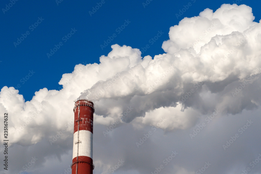 Upper part of the smoking pipe of a power plant against a blue sky. Upper part of the smoking pipe of a power plant against a blue sky.