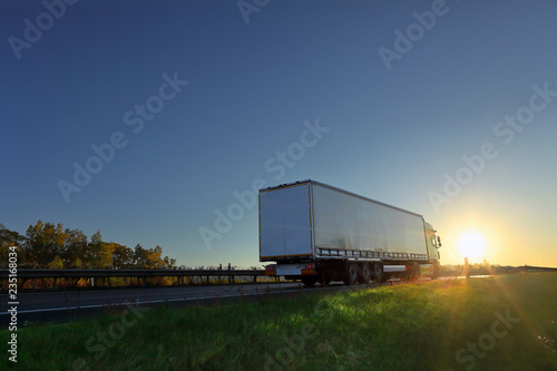 Truck transport on the road at sunset
