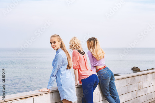 Portrait of three young female friends walking near sea