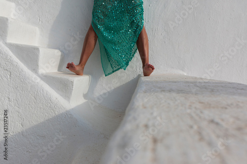 piernas de mujer con vestido verde sobre arquitectura blanca ibicenca photo