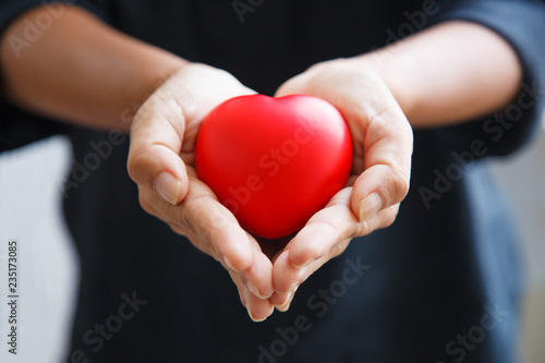 red heart held by female s both hands  represent helping hands  caring  love  sympathy  condolence  customer relationship  patient assistance  life moment  psychological support  service mind concept