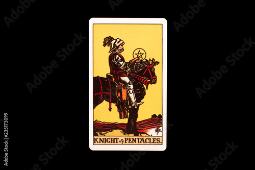An individual minor arcana tarot card isolated on black background. Knight of pentacles.