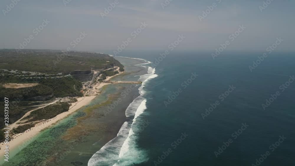 Aerial view rocky seashore with sandy beach. seascape ocean surf and tropical beach large waves turquoise water crushing on beach Melasti, Bali,Indonesia. Travel concept. Aerial footage Aerial view rocky seashore with sandy beach. seascape ocean surf and tropical beach large waves turquoise water crushing on beach Melasti, Bali,Indonesia. Travel concept. Aerial footage