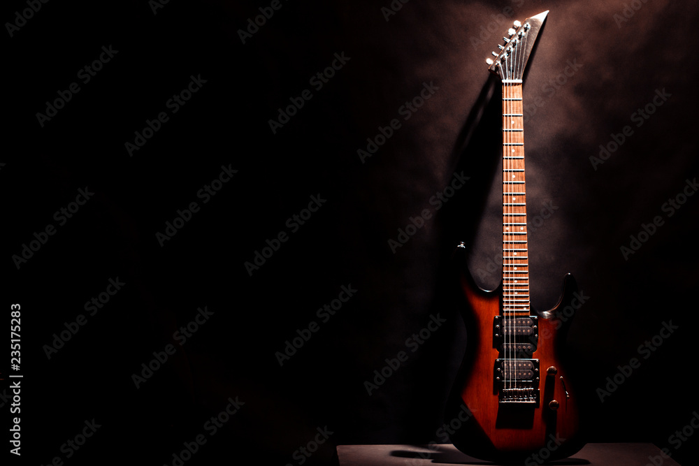Red electric guitar on a dark background. - obrazy, fototapety, plakaty 