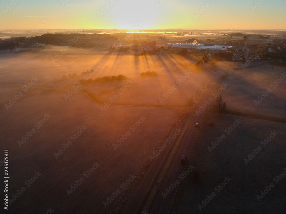 Aerial view on rising sun over frosted foggy valley.