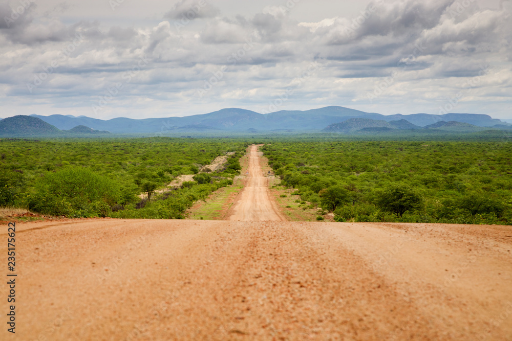 Fototapeta premium Gravel road with Zebra Mountains in Namibia
