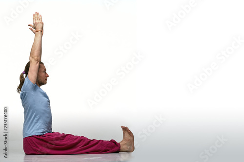 Bearded longhair man practicing yoga. Model doing exercises isolated on white background. Dandasana pose. Full length photo