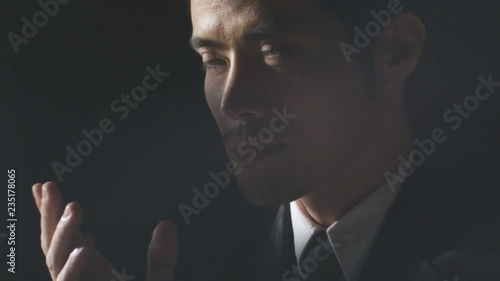 close up of Asian businessman contemplating, looking up and speaking