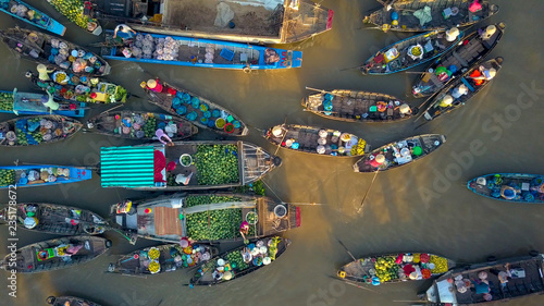 AERIAL: Local people buying and selling colorful produce from wooden boats. photo