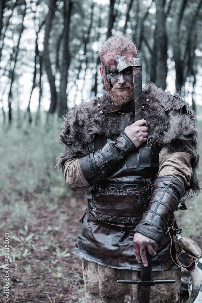 viking with red beard with weapons and armor