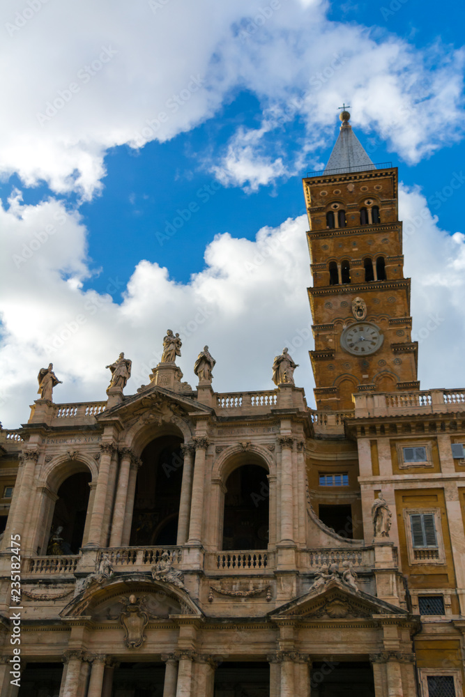 The Bell Tower of the Basilica of Santa Maria Maggiore on Blue Partially Cloudy Sky Background.