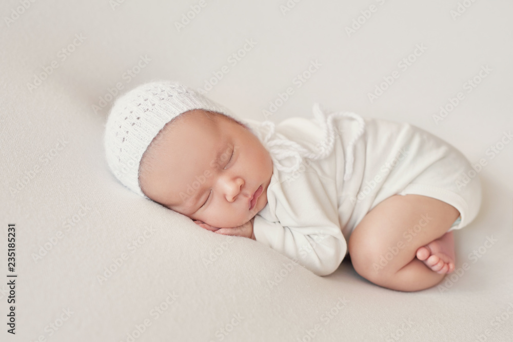 Cute newborn baby girl lies swaddled in a white blanket. Baby goods packaging template. Closeup portrait of newborn baby with smile on face. Healthy and medical concept.  - obrazy, fototapety, plakaty 