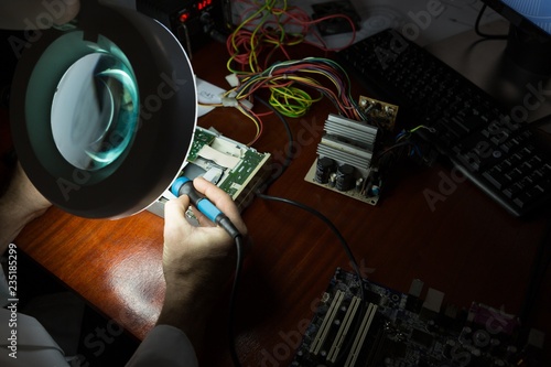 Robotics engineer assembling circuit board at desk photo