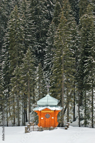 Wooden chapel in a snowy forest.Ukrainian Carpathians, foot of Goverla. © Mykola