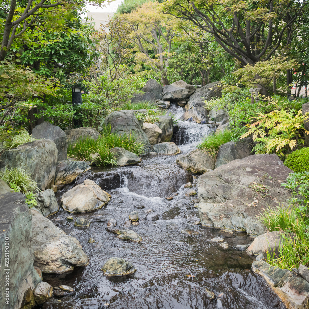 Nature background with view of traditional Japanese garden in Kanazawa, Japan, with rocks and artificial waterfall in November. Nature background with view of traditional Japanese garden in Kanazawa, Japan, with rocks and artificial waterfall in November.