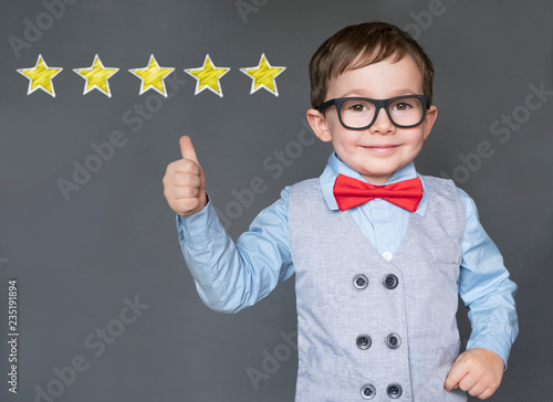 Cute little boy giving thumbs up with 5 stars approved 