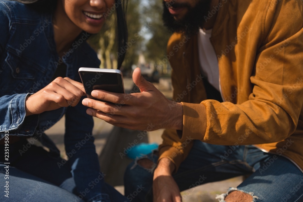 © Wavebreak Media - Couple using mobile phone in city