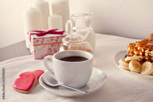 Coffee and a heart shaped cookies  honey  milk and waffles