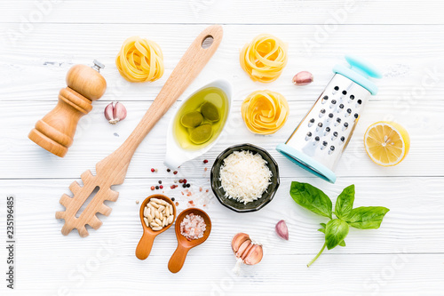 The ingredients for homemade pesto pasta on white wooden background.