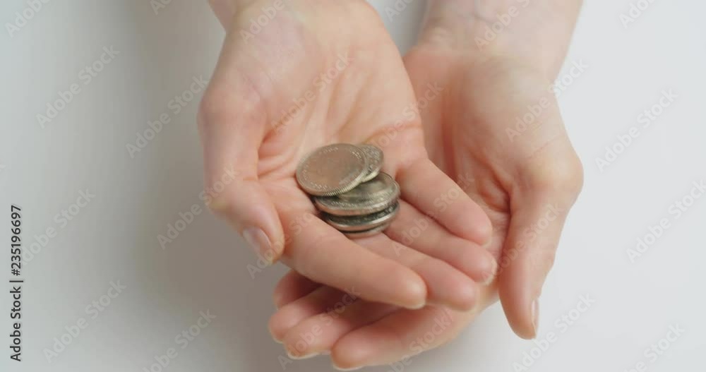 Top view shot of female hands opening and showing a handful of Swiss franc coins.