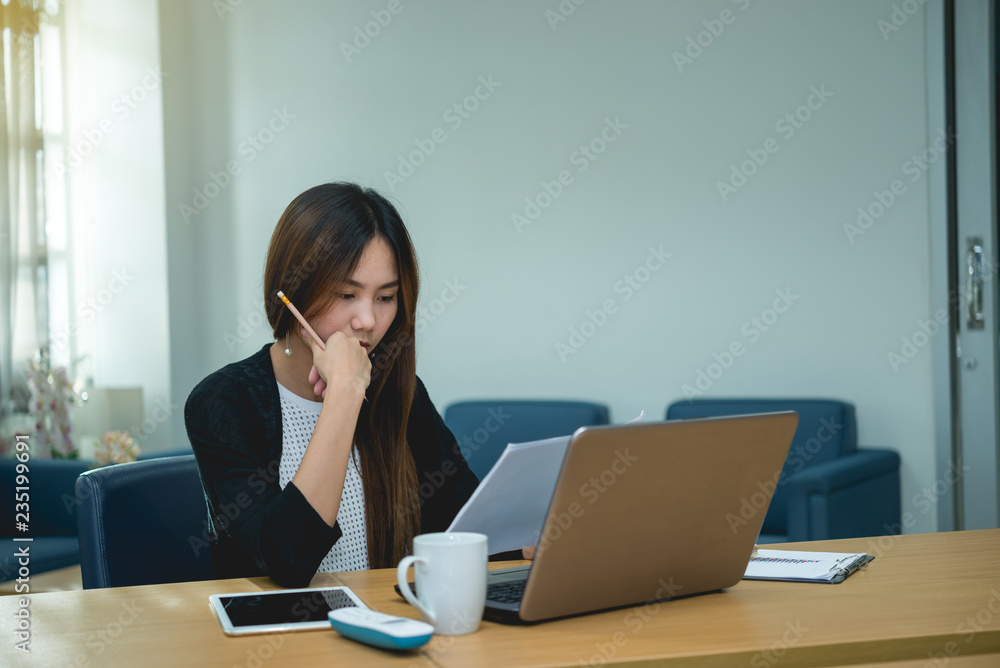 Beautiful asian woman working at the office in the evening,Thailand worker stress from work,Think idea for new product Beautiful asian woman working at the office in the evening,Thailand worker stress from work,Think idea for new product