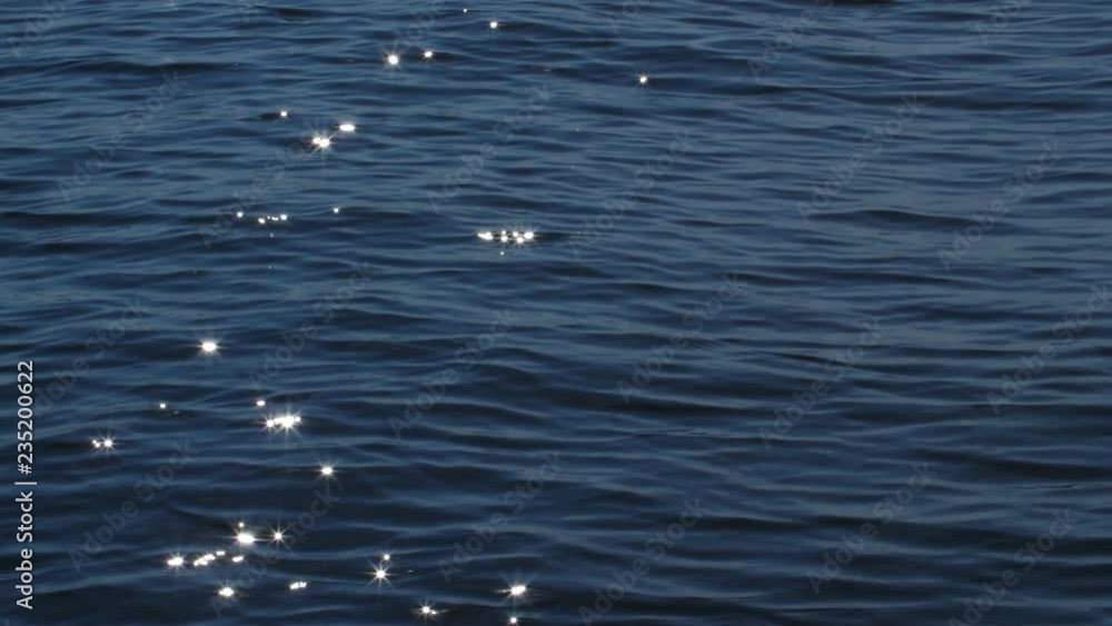 Slow motion water sparkles on lake surface. Wave moving left to right. Slow motion water sparkles on lake surface. Wave moving left to right.