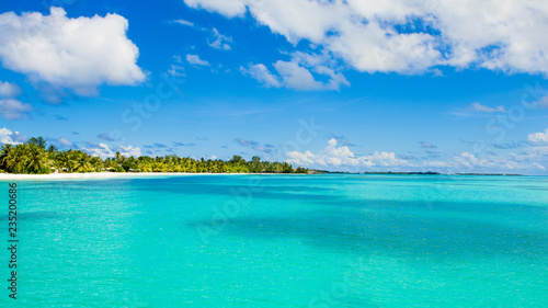 Beautiful sandy beach with sunbeds and umbrellas in Indian ocean, Maldives island